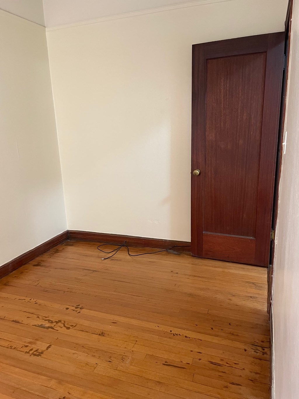 a small room with a wooden floor and a wooden door